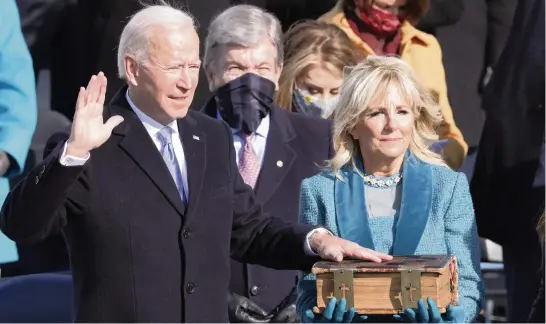  ?? ALEX WONG
Getty Images/TNS ?? Joe Biden is sworn in as president at the Capitol on Wednesday in Washington, D.C., as his wife, Jill, holds a Bible. Biden is now the 46th president of the United States.