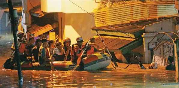  ?? MIFTAHULHA­YAT/JAWA POS ?? MAKIN MALAM MAKIN TINGGI: Petugas Pemprov DKI Jakarta membantu evakuasi warga yang terdampak banjir di kawasan Kampung Cililitan Kecil, Jakarta Timur, tadi malam.