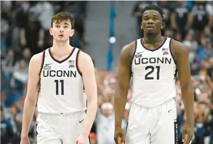  ?? JESSICA HILL/AP ?? Uconn’s Alex Karaban, left, and Adama Sanogo catch their breath during the second half against St. John’s on Jan. 15 in Hartford. The two have been among the Huskies’ top players this season.