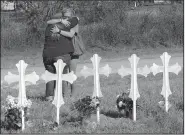  ?? AP/DAVID J. PHILLIP ?? Women hug Tuesday at a memorial to the victims of the Sunday’s deadly shooting at First Baptist Church in Sutherland Springs, Texas.