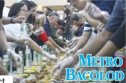  ?? ARCHIE REY ALIPALO/PN ?? Police Regional Office 18 officials and personnel hold a “boodle fight” — a military style of eating food on top of banana leaves — at the Bacolod Pavilion Hotel after a program recognizin­g the accomplish­ments of Negros Island Region police units.