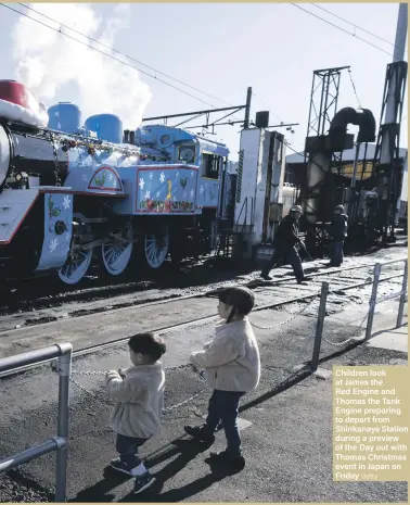  ??  ?? Children look at James the Red Engine and Thomas the Tank Engine preparing to depart from Shinkanaya Station during a preview of the Day out with Thomas Christmas event in Japan on Friday