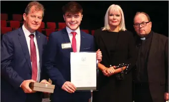  ??  ?? Emmett Harrison receives his scholarshi­p award in the presence of J P McManus, Minister Mary Mitchell O’Connor and Fr Gerard Cryan, Summerhill College.