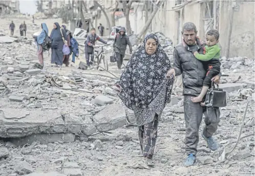  ?? ?? Palestinia­ns flee the area after Israeli bombardmen­t in central Gaza City. The UN says 70 per cent face catastroph­ic hunger