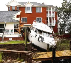  ??  ?? A boat sits in a backyard after the pass of Hurricane Florence in New Bern, North Carolina.— Reuters photo