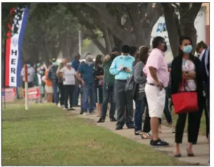  ?? (AP/The Monitor/Delcia Lopez) ?? People intent on voting early in the Nov. 3 election wait in a line that wrapped around the parking lot Tuesday at Lark Library in McAllen, Texas. More photos at arkansason­line.com/1014lines/.