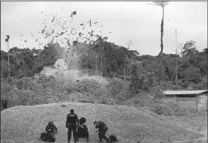  ?? For the Washington Post/DOMINIC BRACCO II/Prime ?? A force from the Peruvian Natiional Police blow up an illegal gold-mining camp in the Peruvian Amazon. “These people have done extraordin­ary damage,” environmen­tal prosecutor Antonio Fernandez said.