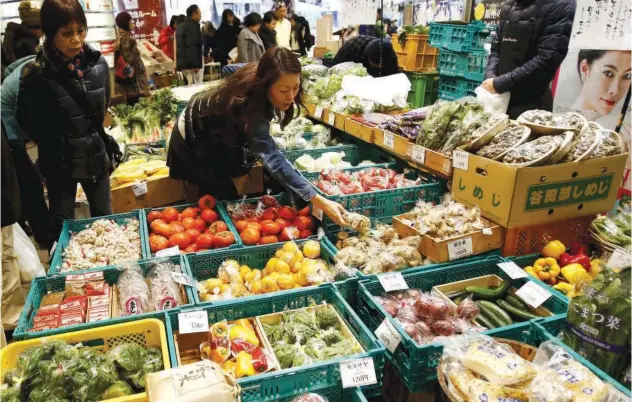  ?? R euters ?? ±
A shopper looks at packs of vegetables at a market in a shopping district in Tokyo, Japan.