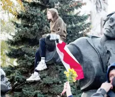  ?? — AFP photo ?? A boy sits on the sculpture of Yakub Kolas square during an opposition rally in support to the nationwide strike in Minsk.