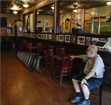  ?? THE ASSOCIATED PRESS ?? Joe Bastone, owner of Yankee Tavern, sits in an empty dining room before the Boston Red Sox played the New York Yankees on Friday, Aug. 14, 2020, in New York. The coronaviru­s pandemic has been especially hard on businesses that rely on ballpark traffic, eliminatin­g crowds at major league games, and leading to rules that limit the amount of people they can have inside their doors at the same time.