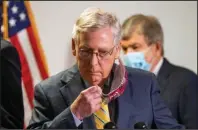  ?? The Associated Press ?? CAPITOL HILL: Senate Majority Leader Mitch McConnell, R-Ky., takes off his face mask as he walks toward the podium following a GOP policy meeting Tuesday on Capitol Hill in Washington. With McConnell is Sen. Roy Blunt, R-Mo.
