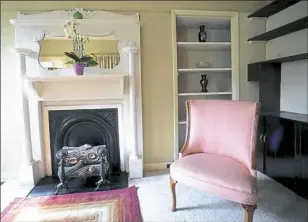  ??  ?? The 16- by- 13-foot living room has a decorative fireplace with mirror and built-in shelving.