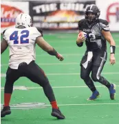  ?? ADOLPHE PIERRE-LOUIS/ JOURNAL ?? Duke City quarterbac­k Caleb Holbrook, right, looks to juke Texas defensive lineman Meshak Williams during Monday night’s semifinal CIF playoff game at Tingley Coliseum.