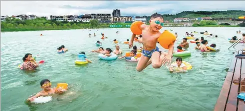  ?? WU YONGJUN / FOR CHINA DAILY ?? Local children swim and play in Cuihu Lake in Pujiang county, the target of Zhejiang province’s “Water Movement” launched in June 2013.