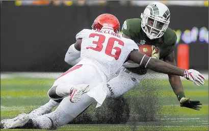  ?? NWA Democrat-Gazette/CHARLIE KAIJO ?? Arkansas nickel back D’Vone McClure (36) brings down Colorado State running back Marvin Kinsey during the first half of Saturday night’s game at Canvas Stadium in Fort Collins, Colo. The Rams outscored the Razorbacks 17-0 in the fourth quarter to take the victory.