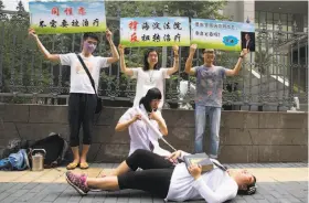  ?? Ng Han Guan / Associated Press 2014 ?? Activists act out electric shock treatment outside a Beijing courtroom in 2014 to protest a case that marked the first victory in gay conversion therapy.