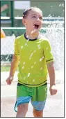  ?? (AP/Craig Mitchelldy­er) ?? Hunter Sack, 7, runs through the water Sunday at a park in Gladstone, Ore., to get some relief from the heat.