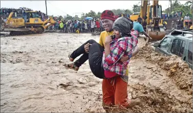  ?? REUTERS ?? A woman is carried across the river La Digue in Petit Goave where the bridge collapsed during the rains of the Hurricane Matthew, southwest of Port-au-Prince, on Wednesday.