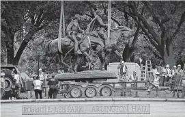  ?? Jae S. Lee / Associated Press ?? The Robert E. Lee statue was loaded onto a trailer truck in 2017 in Dallas. The granite base that supported the statue now will be disassembl­ed and stored.