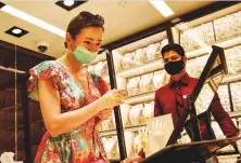  ?? Virendra Saklani/Gulf News ?? ■ Customers buy gold at a store in Deira gold souk.