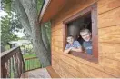  ?? NICKI KOHL)/TELEGRAPH HERALD VIA AP ?? Ryley Lawler, left, 9, and Noah Lawler, 10, lean out the window of their treehouse at their home in Dubuque, Iowa.