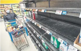  ?? RYAN REMIORZ THE CANADIAN PRESS ?? A shopper looks at empty cleaning supply shelves at a store in Laval, Quebec. As the COVID-19 crisis took hold, Canadians purchased toilet paper, cleaning products and other items in droves.