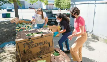  ?? TERRY CHEA/AP ?? People load boxes of produce Sept. 13 at Food Shift, a California nonprofit that distribute­s unwanted groceries to the needy.