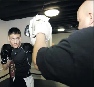  ?? Nikolas Samuels/ The Signal ?? (Above) Tony Duarte, 12, spars with his dad, Luis Duarte, right, at UFC Gym in Canyon Country on Thursday. For training, the Valencia teen wakes up at 5:30 a.m. to workout at College of the Canyons with an Olympic gold medalist. (Below) Duarte holds...