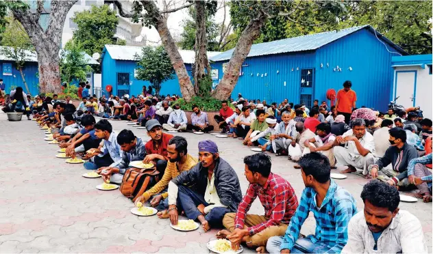  ?? Reuters ?? ↑
Daily wage workers and homeless people eat food inside a government-run night shelter in the old quarters of Delhi on Thursday.