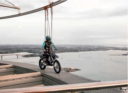  ??  ?? Taka Higashino rode his motocross bike around the Sky Tower in Auckland yesterday.