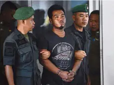  ??  ?? In custody: Ronnakorn is escorted by police into the Koh Sichang police station in Chonburi province, Thailand.