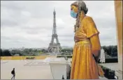  ?? AP/FILE ?? ■
A mask is put on a statue next to Trocadero Square close to the Eiffel Tower in Paris.