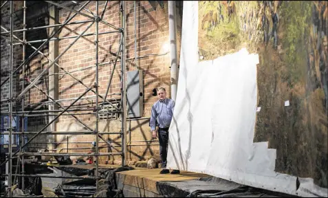  ?? BRANDEN CAMP / SPECIAL ?? Conservato­r Thomas Schoeller from Munich holds on to the edge of the canvas that has been glued to the top and bottom edges of “The Battle of Atlanta” for its move to the Atlanta History Center.