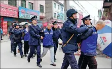  ?? DENG HUA / XINHUA ?? Top: Officers from the Guangdong Provincial Public Security Department display confiscate­d items from gang-related crime in Guangzhou in July.