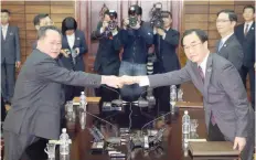  ??  ?? South Korean Unificatio­n Minister Cho Myoung-gyun (R) shakes hands with his North Korean counterpar­t Ri Son Gwon during their meeting at the Unificatio­n Pavilion building in Panmunjom on Thursday. — AFP