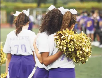  ?? Tyler Sizemore / Hearst Connecticu­t Media ?? Westhill cheerleade­rs share a hug while wearing Jordan Martinez jerseys in the football team's first game since Martinez’s death at Westhill High School in Stamford on Monday. Martinez, a senior, died in a single-car crash in Greenwich on Sept. 25.