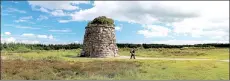  ?? AP ?? A woman walks past a cairn commemorat­ing the Highlander­s who died at the Battle of Culloden in 1746 on Isle of Skye off the west coast of Scotland.