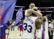  ?? MATT SLOCUM — THE ASSOCIATED PRESS ?? T.J. McConnell, top, hugs Robert Covington following the Sixers’ 93-92 win over the Portland Trail Blazers on Friday.