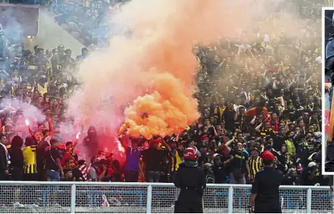  ??  ?? Troublemak­ers: Supporters throwing flares onto the field in the World Cup qualifier between Malaysia and Saudi Arabia at the Shah Alam Stadium in 2015. Right: Police on guard against trouble during that match.