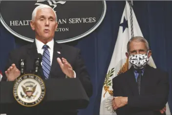  ?? ASSOCIATED PRESS ?? DR. ANTHONY FAUCI (RIGHT) DIRECTOR of the National Institute of Allergy and Infectious Diseases, listens as Vice President Mike Pence speaks during a news conference with the Coronaviru­s task force at the Department of Health and Human Services in Washington on Friday.