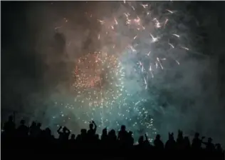  ?? CRAIG RUTTLE — THE ASSOCIATED PRESS ?? Spectators watch a fireworks display on the east side of Manhattan borough, as part of Independen­ce Day festivitie­s Wednesday in New York.