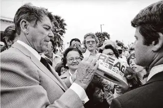  ?? Associated Press file photo ?? Ronald Reagan signs a hat in Harlingen in 1976 as he campaigned for votes and wooed Texas Democrats to cast ballots in the Republican primary.
