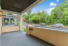  ?? Ryan Tingle/Fly Over Properties ?? Covered front porch looks out to wooded city property across the street.