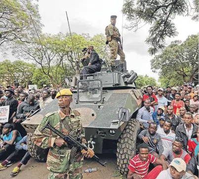  ??  ?? SURGE: Soldiers on guard as protesters in Harare, Zimbabwe, demand that president Robert Mugabe quits