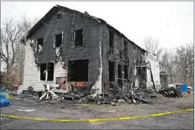  ?? JESSICA HILL/AP PHOTO ?? Charred siding and items are strewn about at a two-family home Wednesday in Somers in the aftermath of a fatal fire. Four children died Tuesday night in a fire that broke out in the two-family home. The children, ages 5, 6, 8 and 12, were found inside the house where 11 people lived, fire and town officials said.