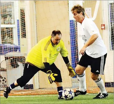  ?? Special to the Herald ?? Ron Dirksen of Harvey Lister Webb guards the front of the net as goalkeeper Tom McGill gathers the ball during indoor soccer action on Sunday. HLW beat TC Auto Sales 6-4.