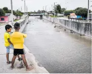  ?? CéSAR BOLíVAR ?? Dos niños se asoman al canal. La comunidad teme que una persona pueda caerse por la falta de barandas.