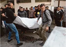  ?? Ahmad Hasaballah/getty Images ?? People receive the bodies of World Central Kitchen workers Tuesday. They were killed by Israeli airstrikes while driving in a convoy after unloading aid in Gaza.