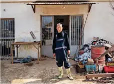  ?? ?? Manthos Kolonas stands in front of the building where his electrical appliance store was housed. All his tools were destroyed after being left in the water for so many days.