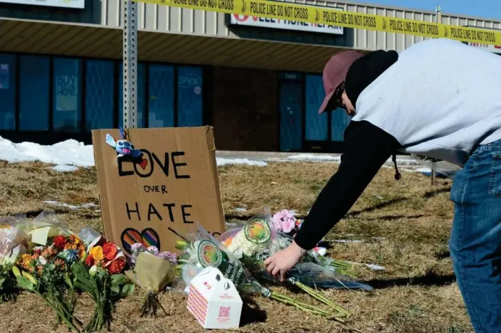  ?? Photograph: Geneva Heffernan/AP ?? Elijah Newcomb lays flowers near a gay nightclub in Colorado Springs, Colorado, on Sunday, where a shooting occurred late Saturday night.